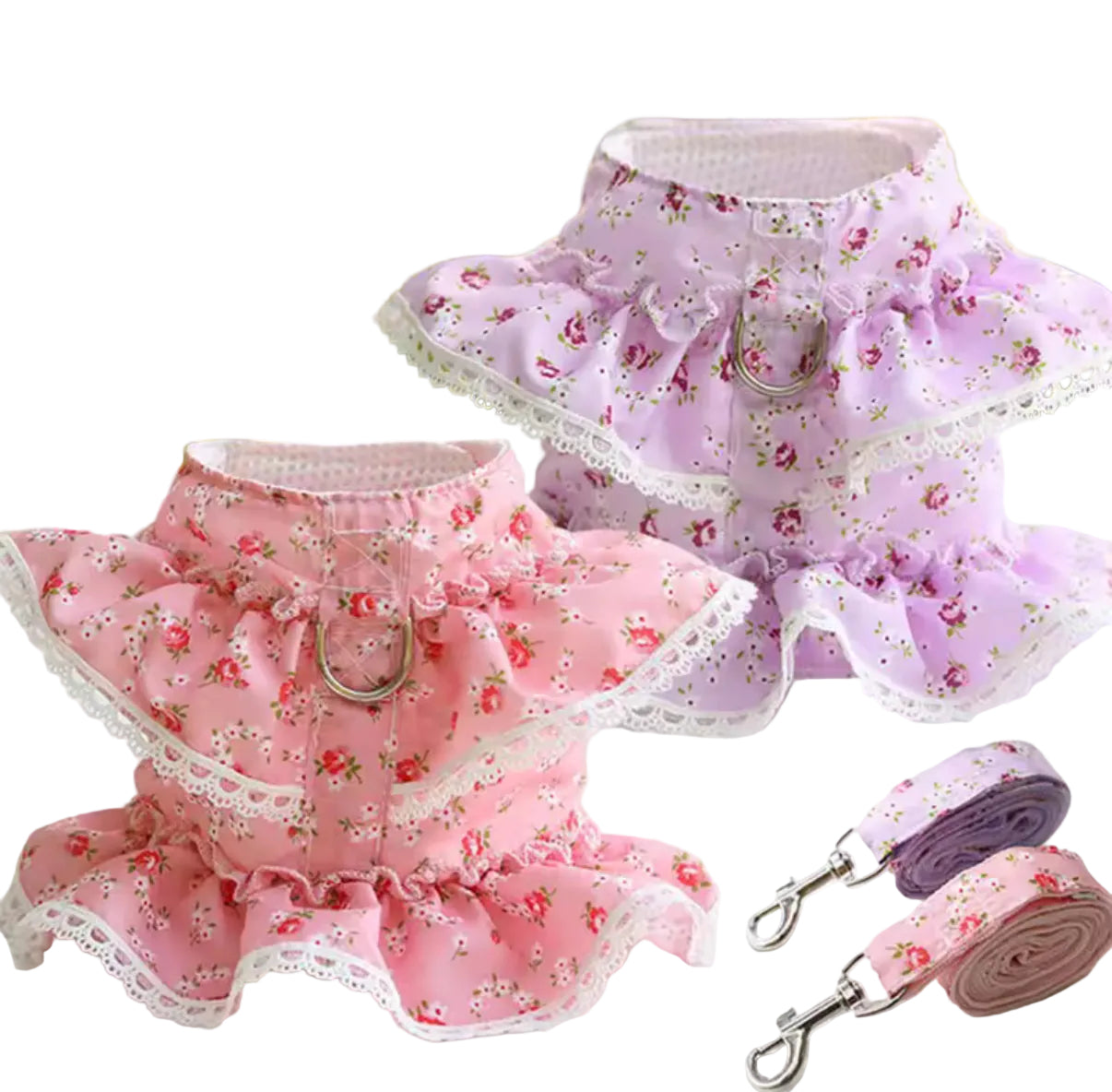 Pink and purple pet harnesses with floral patterns on a white surface.